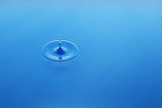 Water drop on blue background, waves on water