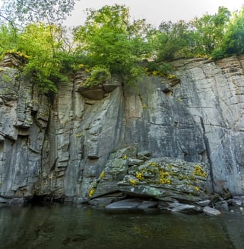 Panoramic photo of high rock wall on mountain river