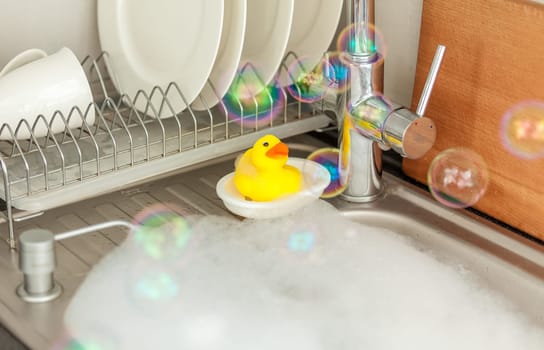 Closeup photo of yellow duck in sink on kitchen