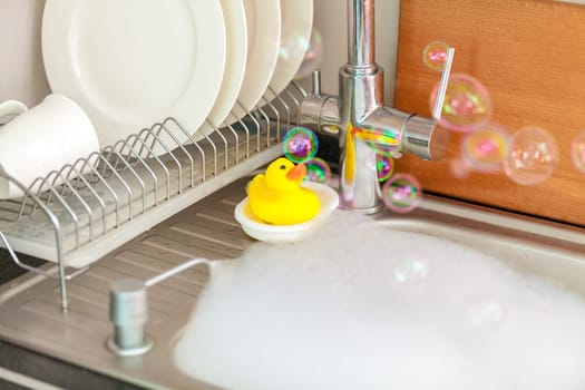 Closeup photo of yellow duck on kitchen sink in foam