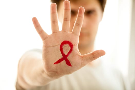 Closeup photo of man showing hand with drawn red AIDs loop