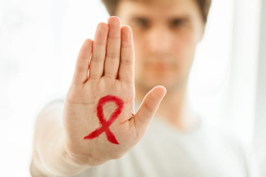 Portrait of young man holding arm in front f him with drawn red loop