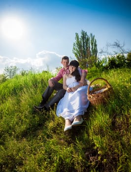 Happy just married couple having picnic at meadow