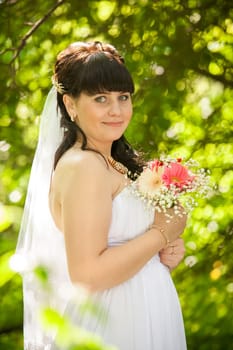Closeup portrait of cute brunette bride at summer park