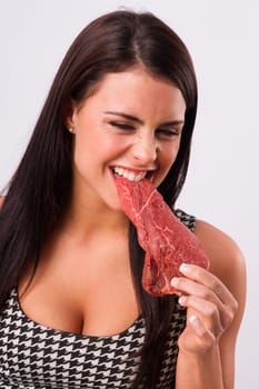 Woman bites into red steak meat