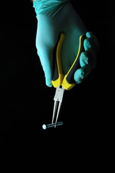 Pliers and a Hand on a Black Background