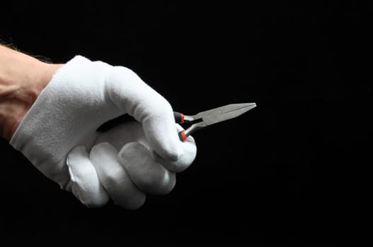 Pliers and a Hand on a Black Background