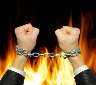 Hands in chains on a fire  background