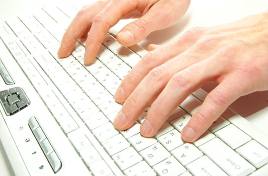 male hands typing on a white computer keyboard