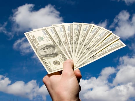 Money in hand  isolated on sky background