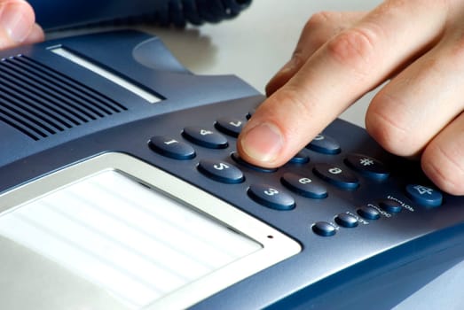 finger with  blue telephone keypad