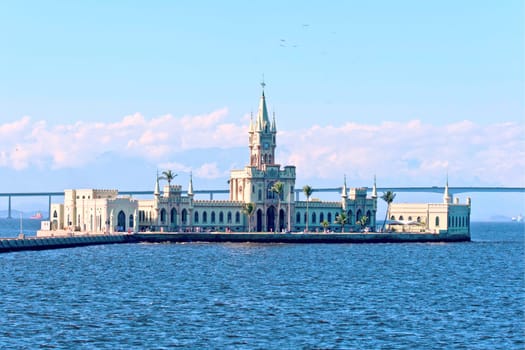 Little green castle surrounded by coconut trees and palm trees on a small Fiscal island in Guanabara Bay, Rio de Janeiro - Brazil. Famed as the venue of the last ball hosted by the Brazilian Empire on 9 November 1889, Fiscal Island stands out in the landscape and is an attraction open to the public