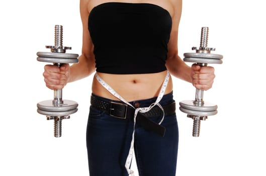 A closeup picture of the front section of a young woman in jeans, holding.two dumbbell's and a tape around her body, isolated on white background..