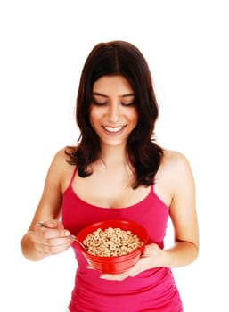 A nice brunette young woman in a red t-shirt holding a bowl of cereal.in her hand for breakfast, isolated on white background..