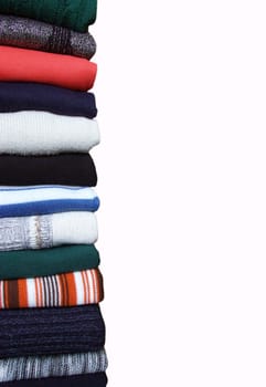 Heap of sweaters of clothes on a whiteness