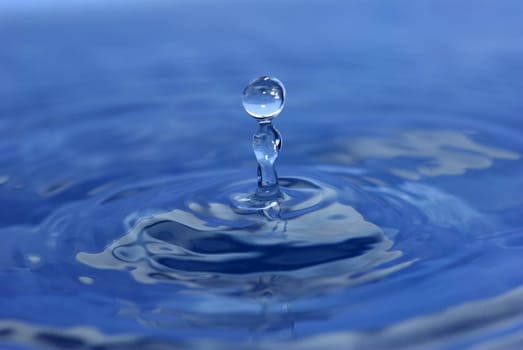 The round transparent drop of water falls downward