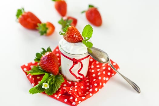 Fresh yoghurt with strawberries in a glass insulated on a white background