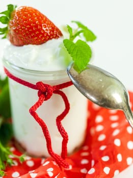 Fresh yoghurt with strawberries in a glass insulated on a white background