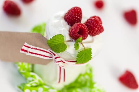 Fresh yoghurt with raspberries in a glass insulated on a white background