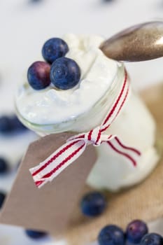 Glass with yoghurt and fresh blueberries blueberries for breakfast and for dessert
