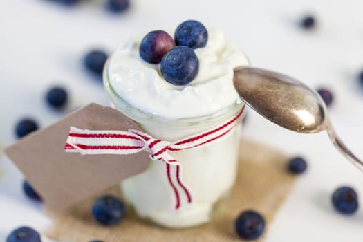 Glass with yoghurt and fresh blueberries blueberries for breakfast and for dessert