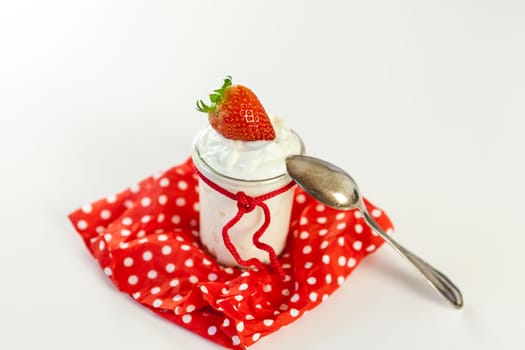 Fresh yoghurt with strawberries in a glass insulated on a white background