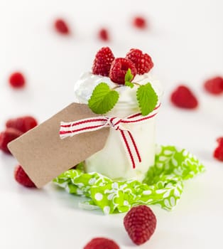 Fresh yoghurt with raspberries in a glass insulated on a white background