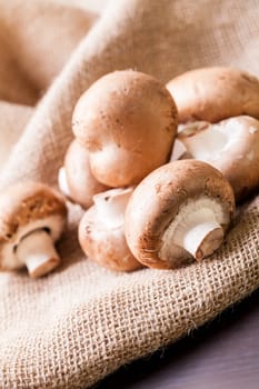 Fresh braund champignons in sunlight on a wooden table in daylight