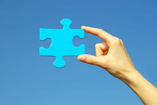 puzzle in hand isolated on blue background
