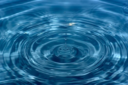 The round transparent drop of water falls downward