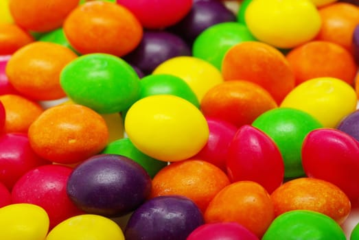 Set of sweet dragees of different color on white background