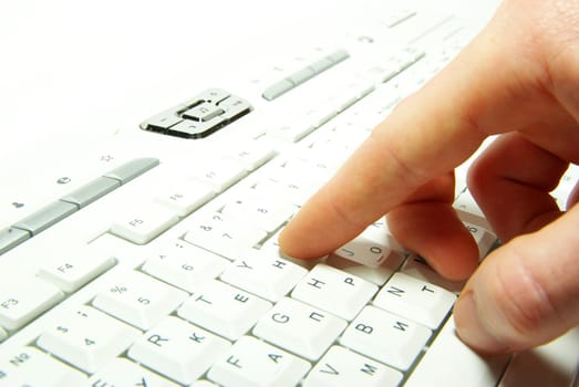 male hands typing on a white computer keyboard