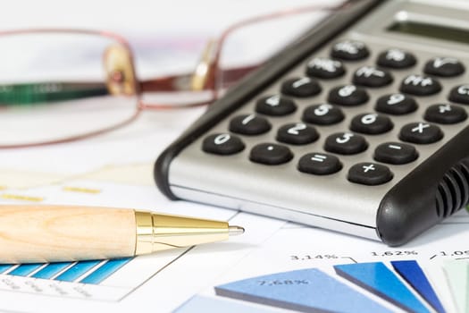 Business chart with  calculator, pen and glasses