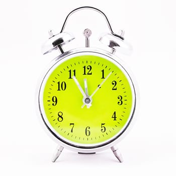 Alarm clock on white background. Showing time five minutes before twelve