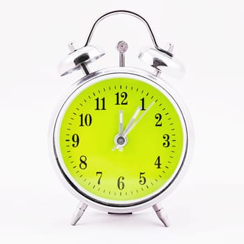 Alarm clock on white background. Showing time five minutes past twelve