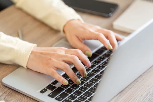 A dedicated freelance professional types on her laptop at home, highlighting focus and productivity in her work.