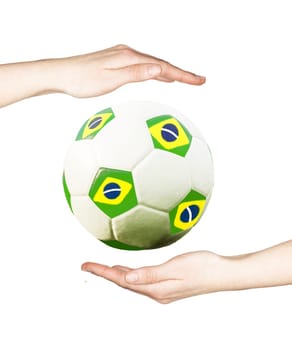 Hands holding soccer ball with the colors of Brazil flag