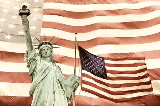 Statue of Liberty with two American flags. Large American flag in the background.Processed in subdued tones of color.