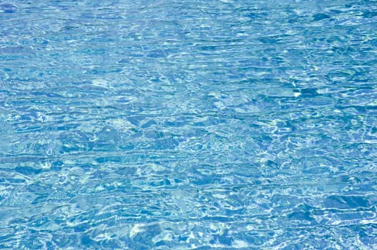 Blue pool water with sun reflections
