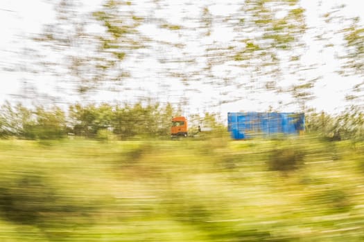 Truck delivery oversized cargo behind the trees