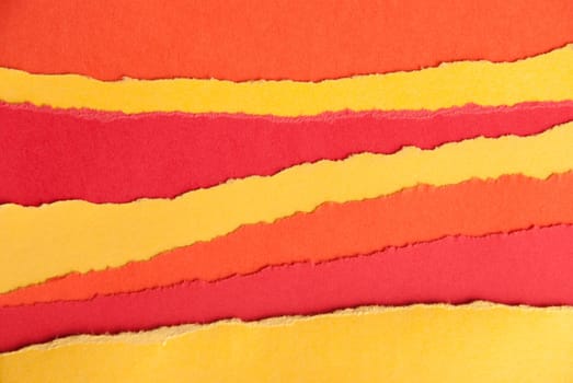 Ripped Red and Orange and Yellow Paper in Stripes as a Paper Background
