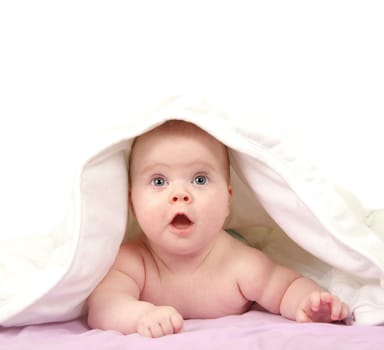 baby looking out from under blanket