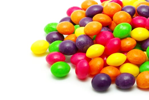 Set of sweet dragees of different color on white background