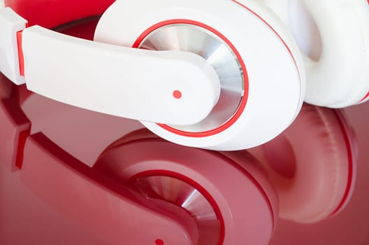 White red headphones on vinous clear polished mirrored surface