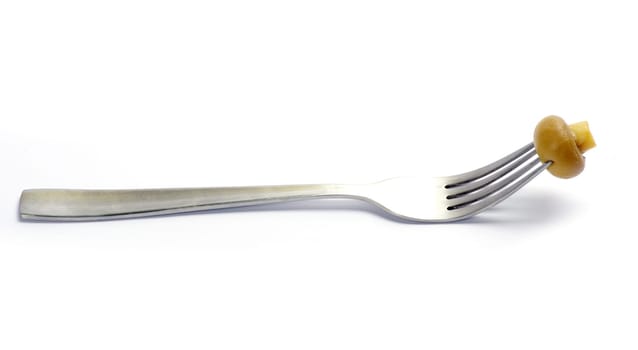 Fresh mushroom on a fork isolated on white background