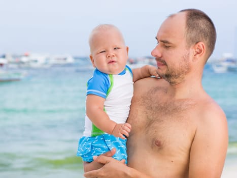 Baby and father on the tropical beach