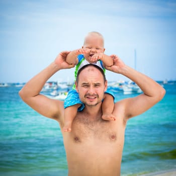 Baby and father on the tropical beach