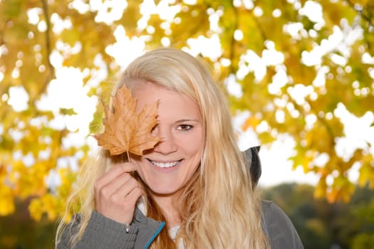 young woman with autumn leaf