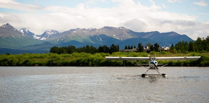 A bush plane performs take off/landing in Alaska with Chugach Mountains in the Background