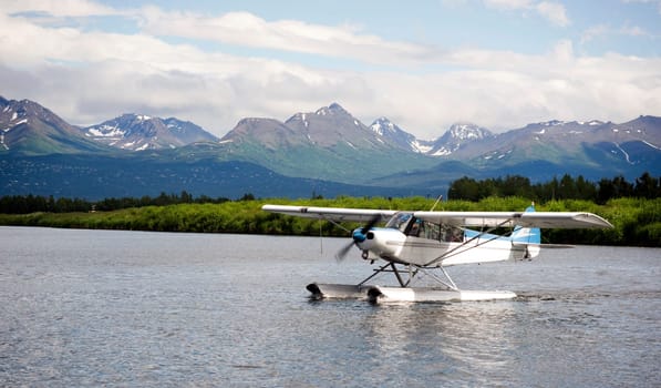 A bush plane performs take off/landing in Alaska with Chugach Mountains in the Background